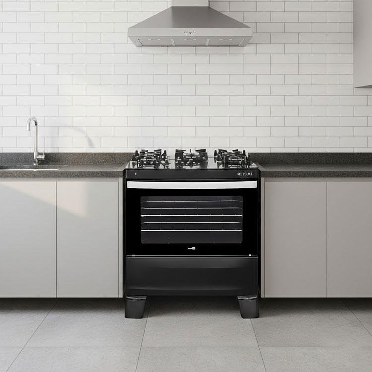Black tempered glass gas range with vent hood.