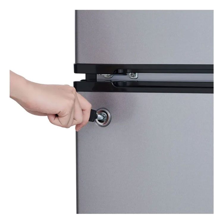 A hand is shown inserting a key into the lock on the door of a silver mini refrigerator.
