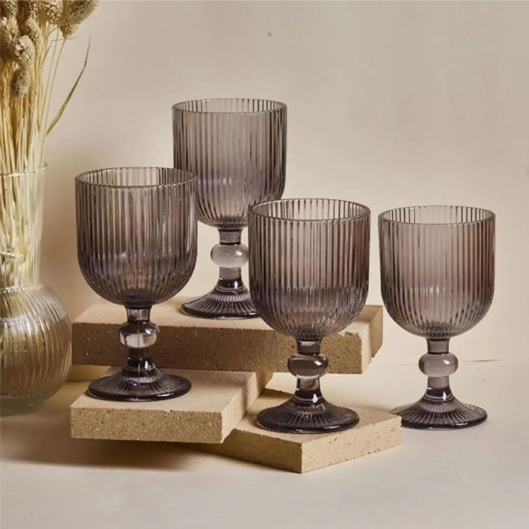 Four smoky gray ribbed wine glasses on display.