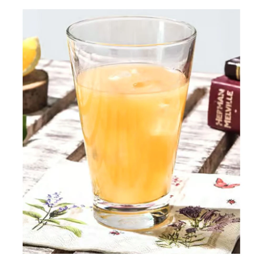 Transparent glass filled with orange juice and ice cubes