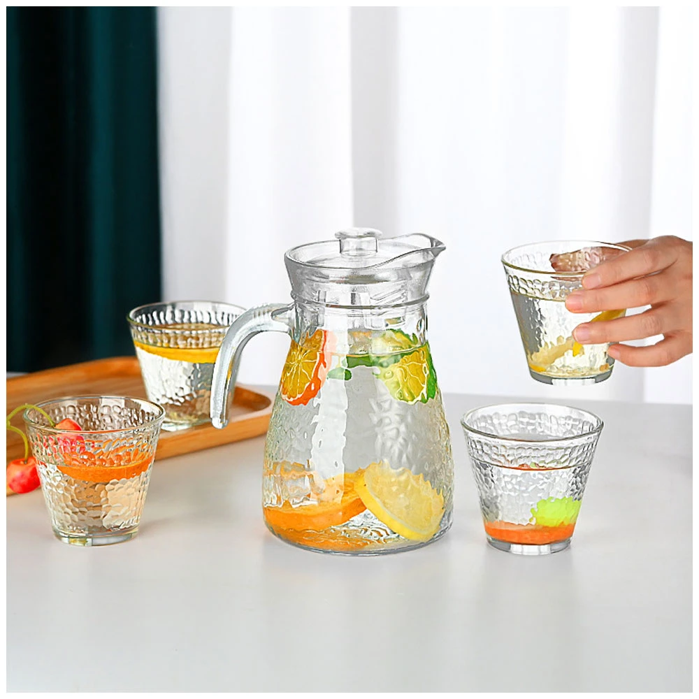 Glass pitcher with handle, filled with water and citrus fruits