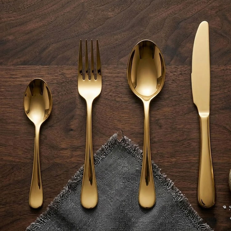 Gold cutlery set on dark wooden table