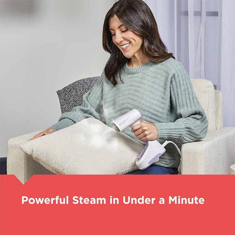 Woman using handheld fabric steamer on furniture pillow.