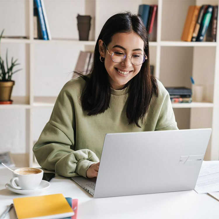 Woman working happily on ASUS Vivobook laptop